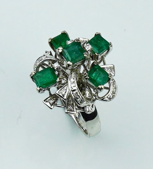 18KWG Emerald & diamond cluster ring.: An 18KWG Emerald & diamond cluster ring. Size 7, stamped and tested 18K white gold, five prong set emerald cut emeralds approx. 4.8mm x 4.8mm, 18 round faceted diamonds approx. 16cttw., gross weight a
