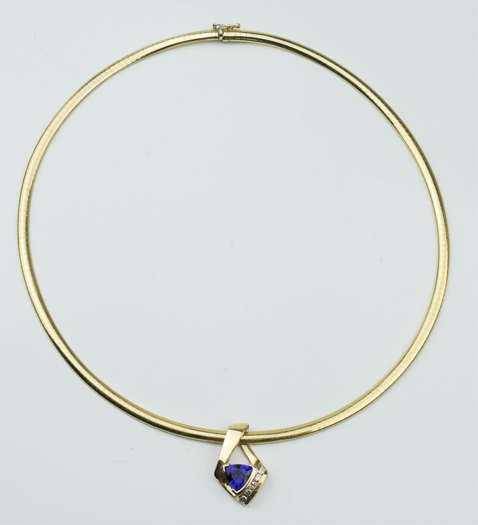14KYG Omega Necklace, Tanzanite and Diamond Slide.: A 14KYG Omega Necklace, Tanzanite, and Diamond Slide. Necklace stamped and tested 14K yellow gold approx. 16.0 inches x 3/16 inch, gross weight approx. 11.35dwt. ++ Stamped and tested 14K yellow gold 