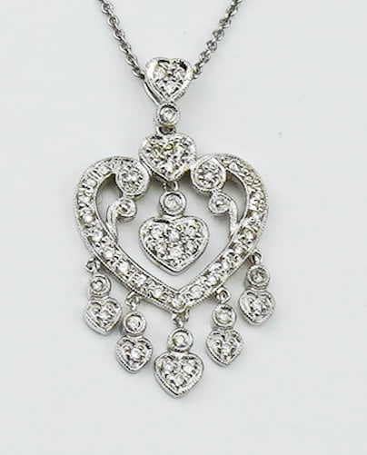 18KWG Diamond tasseled heart pendant & 14KWG chain: An 18KWG Diamond tasseled heart pendant & 14KWG chain. Approx. 16.0 inches stamped and tested 14K white gold open link pendant chain with stylized heart shaped tasseled pendant approx. 1 1/4 inches x 