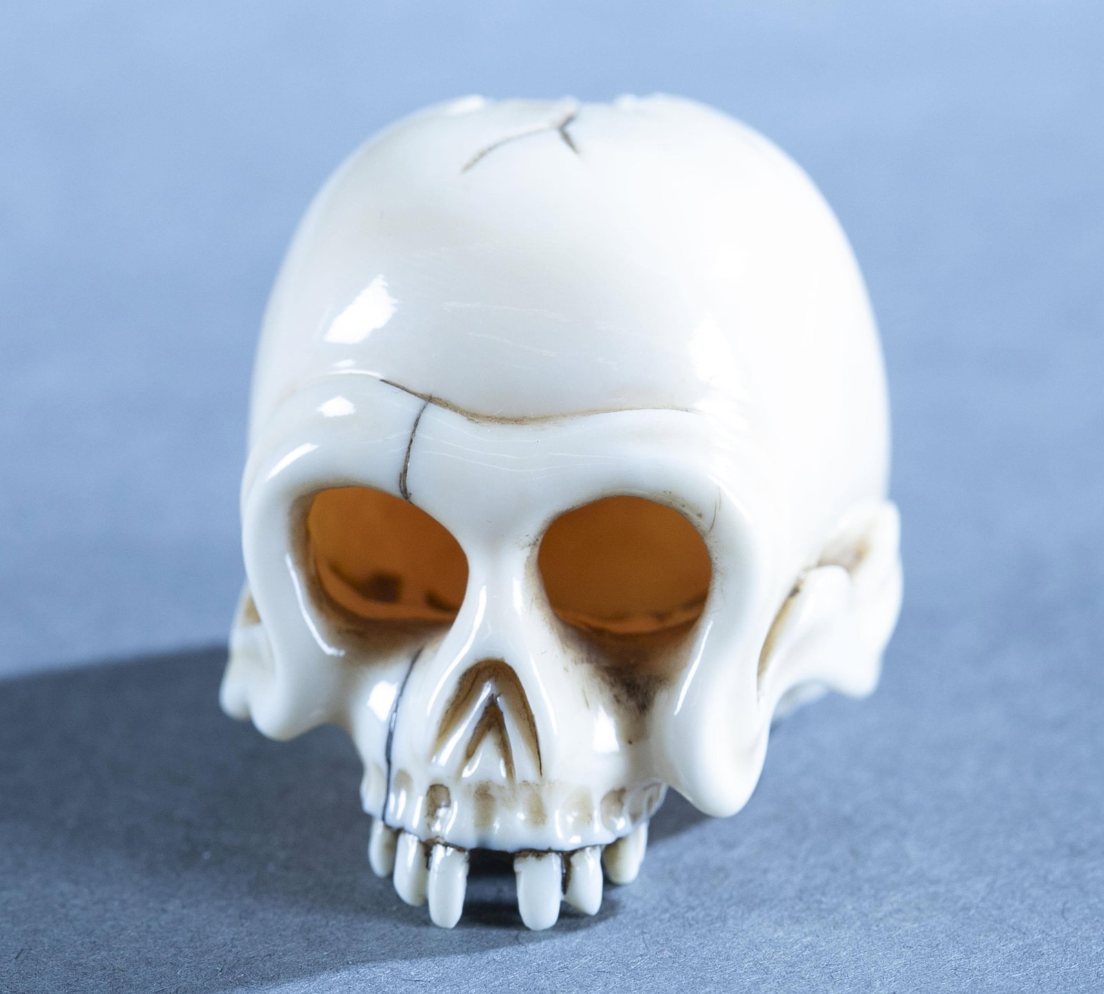 Japanese netsuke of human skull.: A Japanese ivory netsuke of human skull. Early 20th century. Himotoshi on the back of the skull with small signature to the right of them. 1 3/8" x 1 7/8" x 1 3/8".
