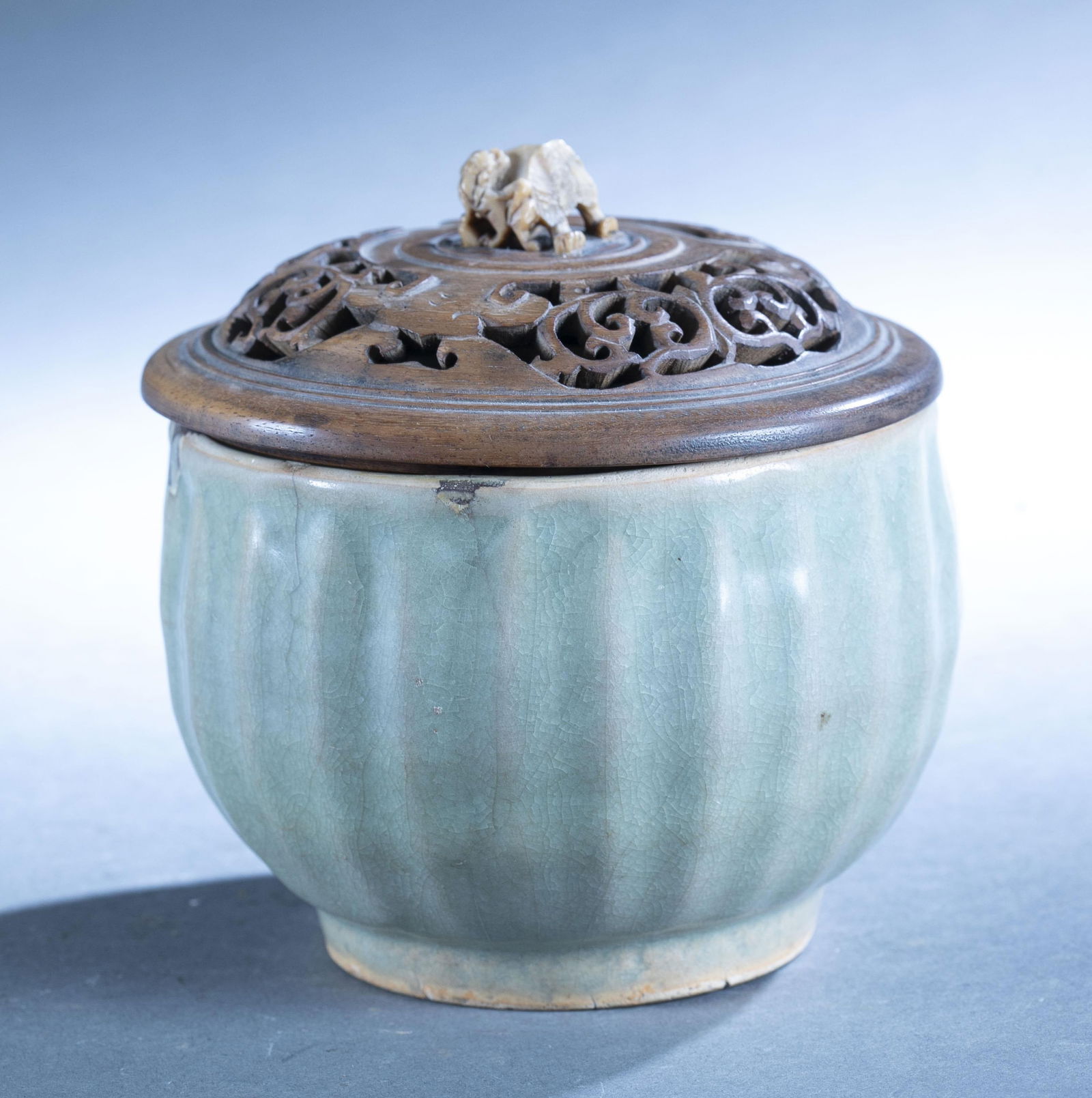 Chinese celadon bowl with lid.: A Chinese celadon bowl with wooden lid with stone Foo Dog finial. 5 1/2" x 5 1/2".Hairline cracks and repairs. Loss on finial.