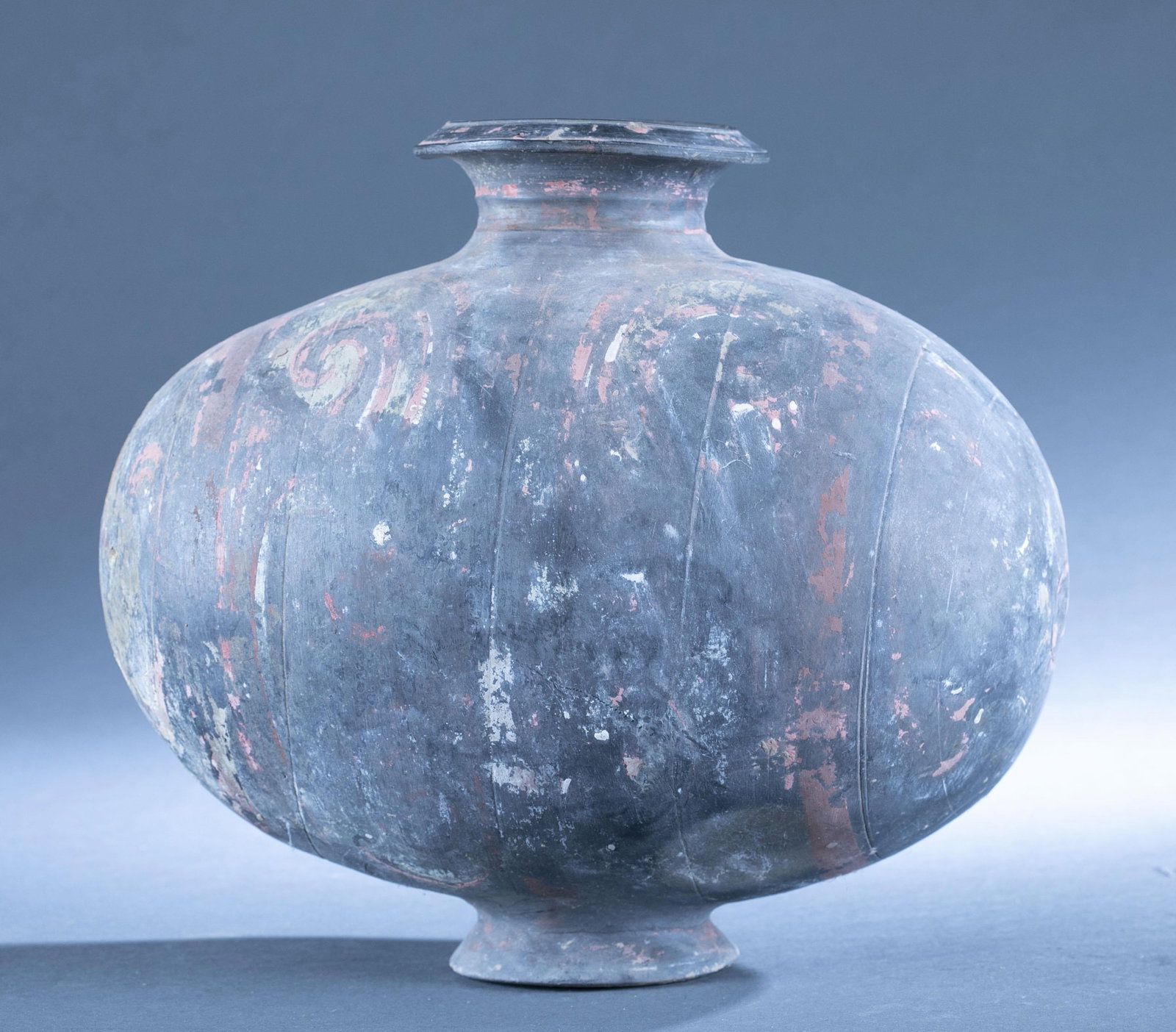 Chinese Han Dynasty cocoon jar.: A Chinese Han Dynasty polychrome cocoon jar. Red and white scroll pattern. 11 1/2" x 13" x 9".