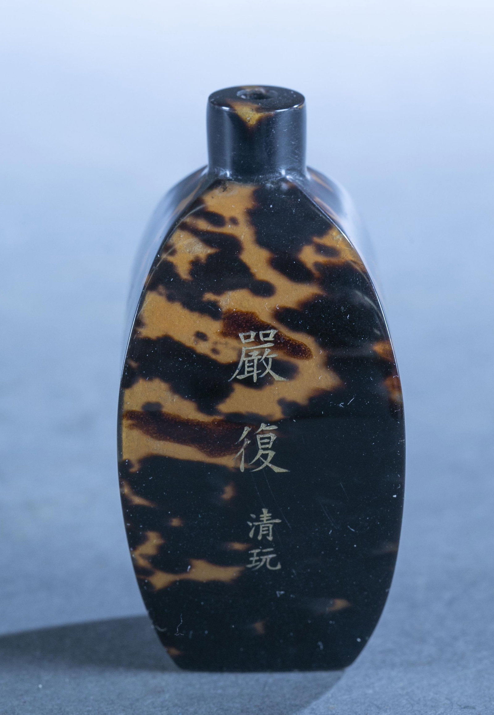 Chinese tortoiseshell snuff bottle.: A Chinese tortoiseshell snuff bottle. Gold writing on all sides and bottom. 2.8" x 1.4" x 1.3".