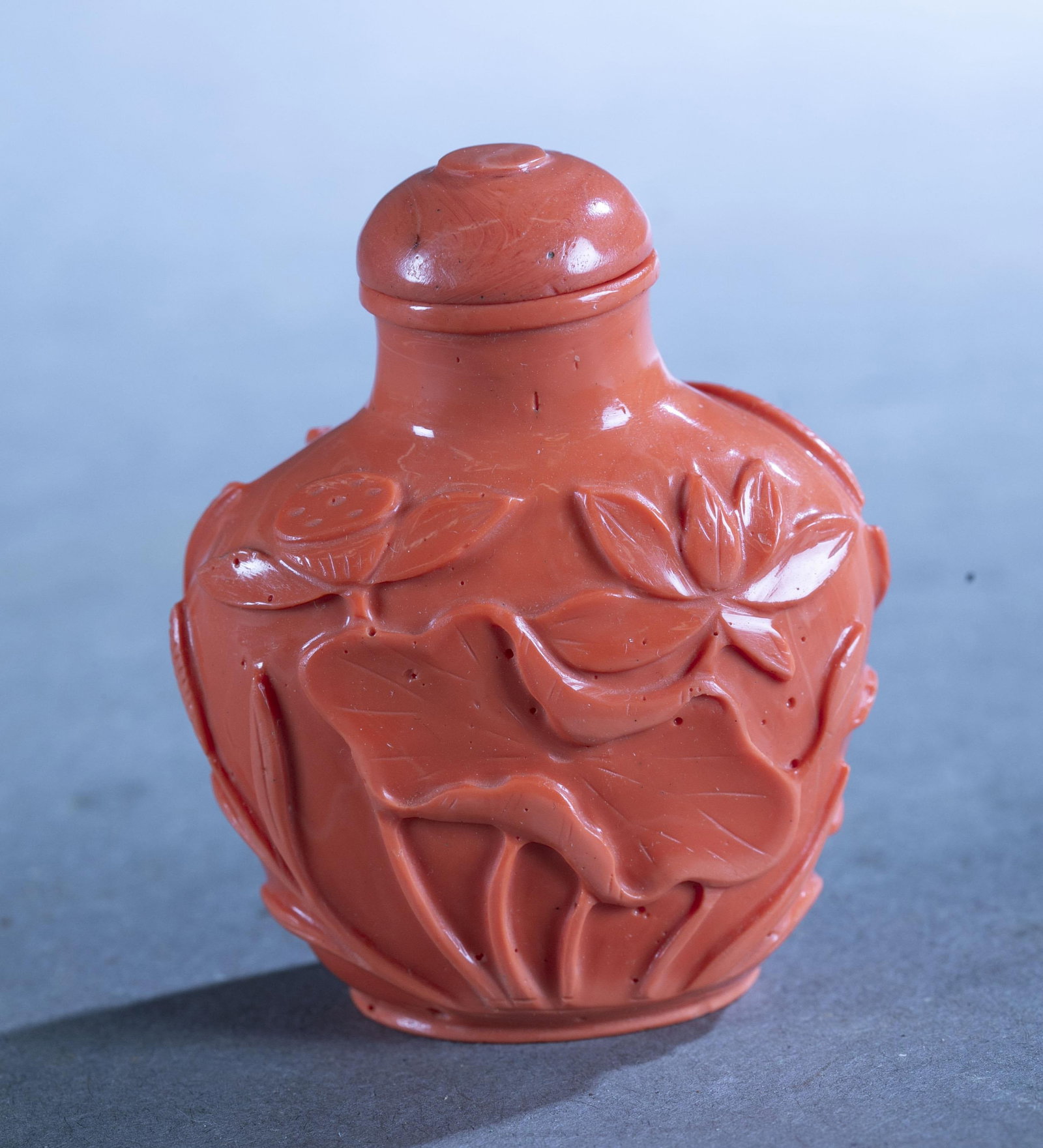 Chinese carved coral snuff bottle.: A Chinese carved coral snuff bottle. 2.7" x 2.1" x 1.4".