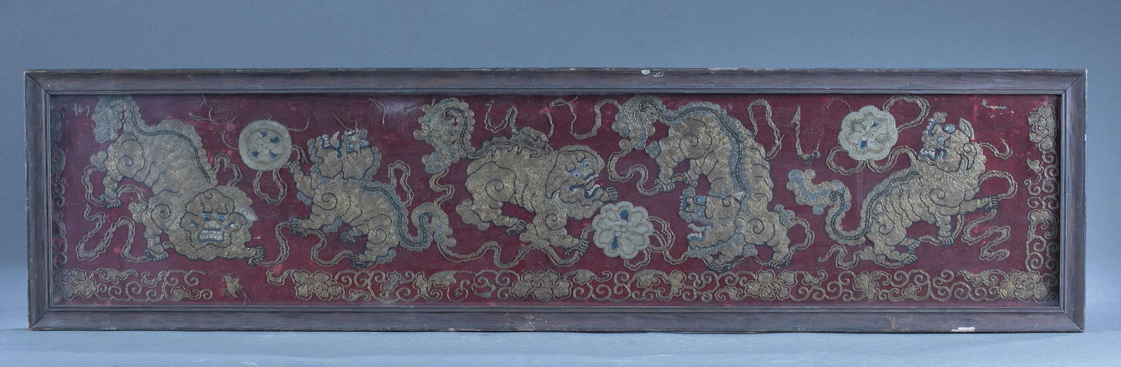 Chinese embroidered panel.: A Chinese embroidered panel of gilt Foo Dogs on red field. 40" x 10".