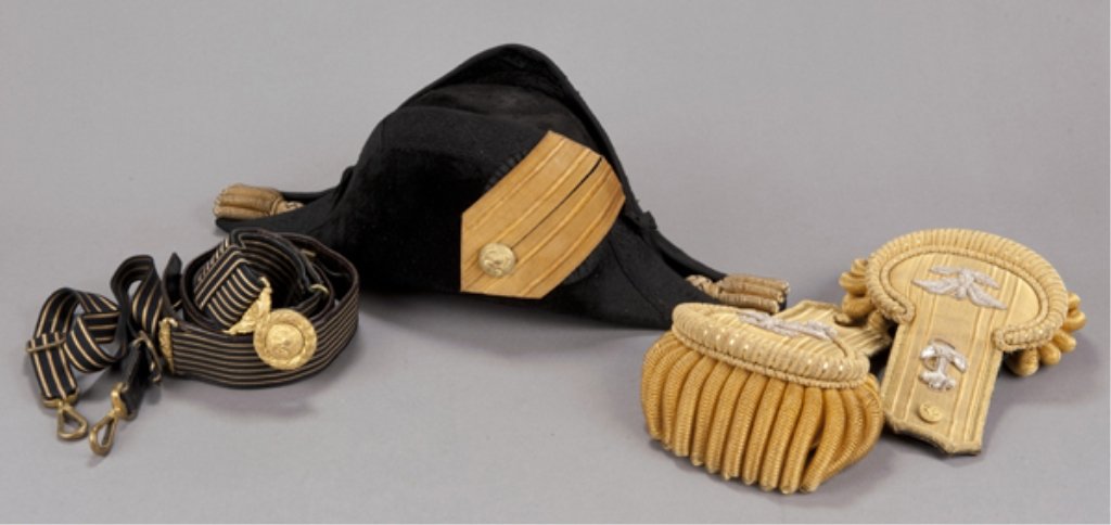1898 Lt. Commander U.S. Navy hat, epaulets, belt. D: Dress uniform accoutrements contained in original metal velvet-lined carrying case inscribed "W.V. Tomb U.S.N." Consists of beaver fur parade hat, pair of fancy gold epaulets with silver eagle and anc