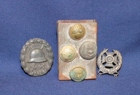 Lot of German WWI pins incl Black Wound badge pin w: with helmet, pin with cross inside wreath, & matchbox cover with various buttons adhered.