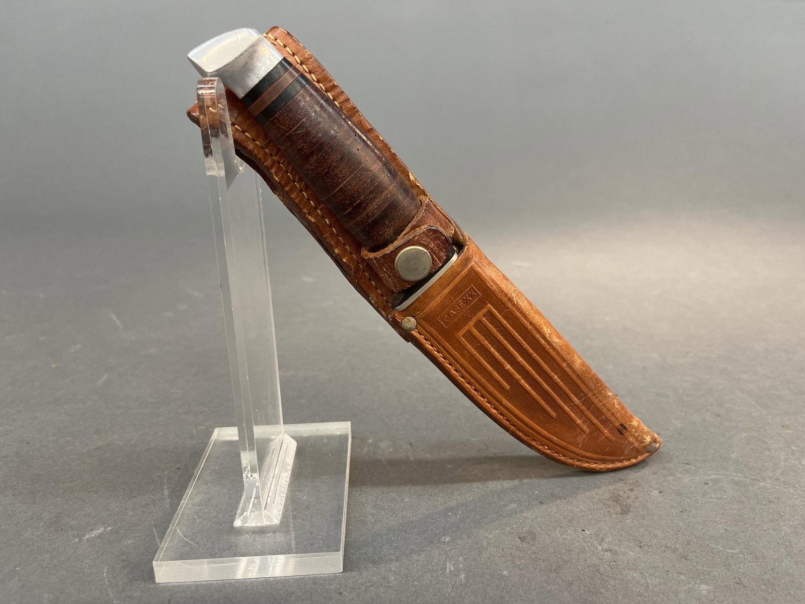 Vintage CASE hunting knife with sheath: A vintage CASE hunting fixed blade knife with sheath, Circa 1960-1965.5" blade. Tang marked CASE (serifs). Stacked leather grip. Period CASE leather holster. Condition: Rust on tang of knife. Provenan