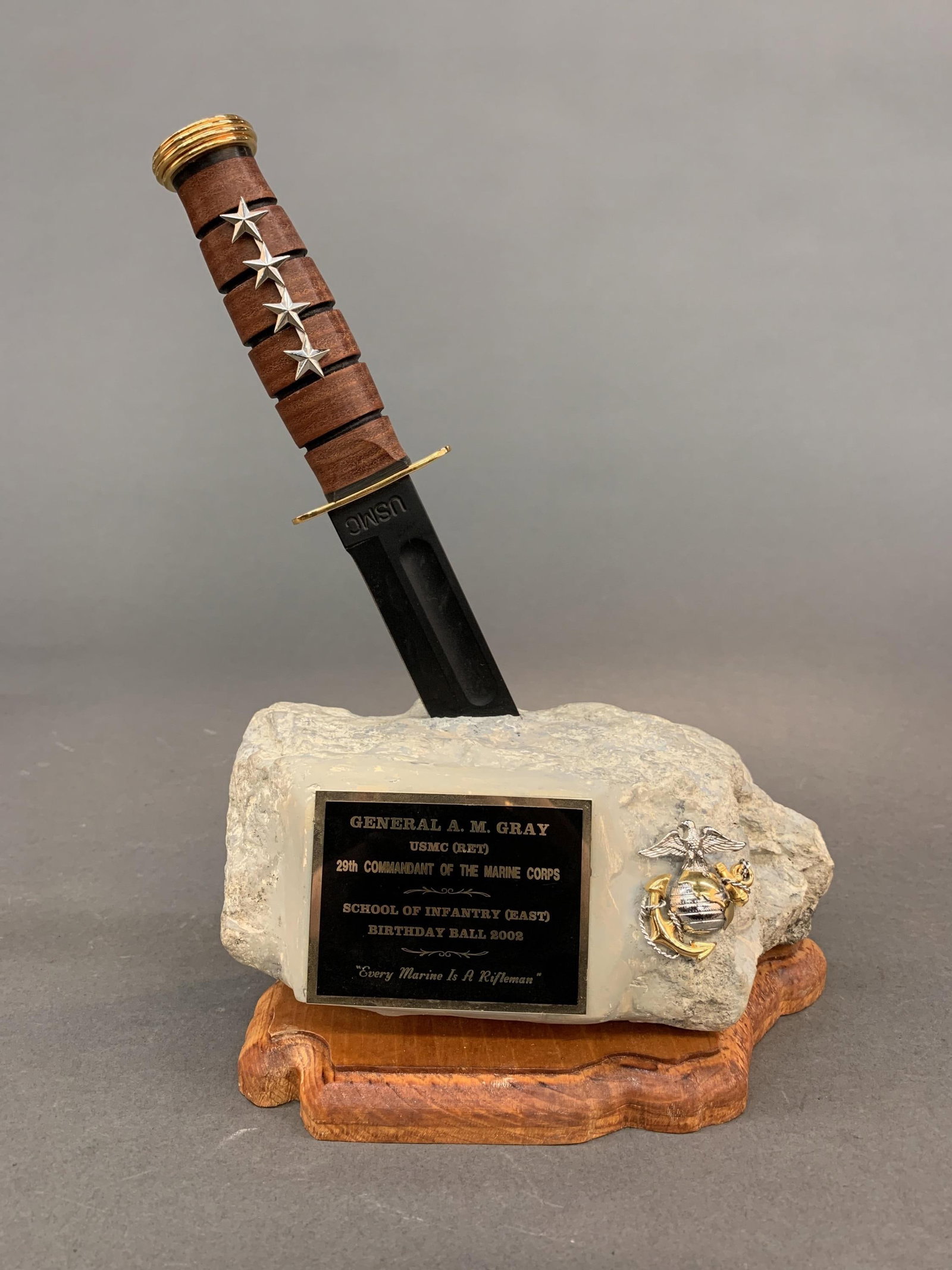 Gen. Gray School of Infantry Ball award: A General Alfred M. Gray Jr. School of Infantry (East) Birthday Ball award. KA-BAR with gold plated pommel and crossguard with four silver stars embedded in a stone with a U.S.M.C. hat pin and plaque.