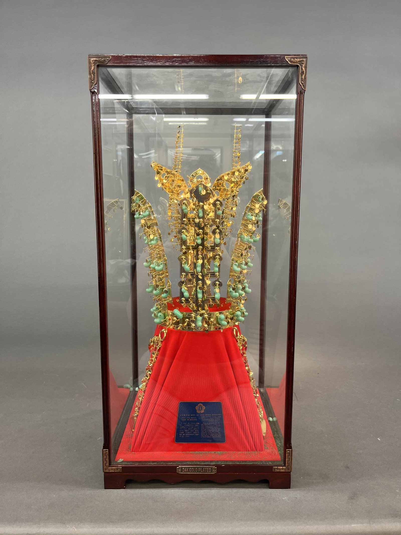 Reproduction gold crown of Cheonmachong: A reproduction of The Gold Crown from Cheonmachong in Gyeongju National Museum, Korea. 24K gold plated. In wood and glass display case. 25" x 11 1/2". Provenance: From the estate of U.S.M.C. Four Star