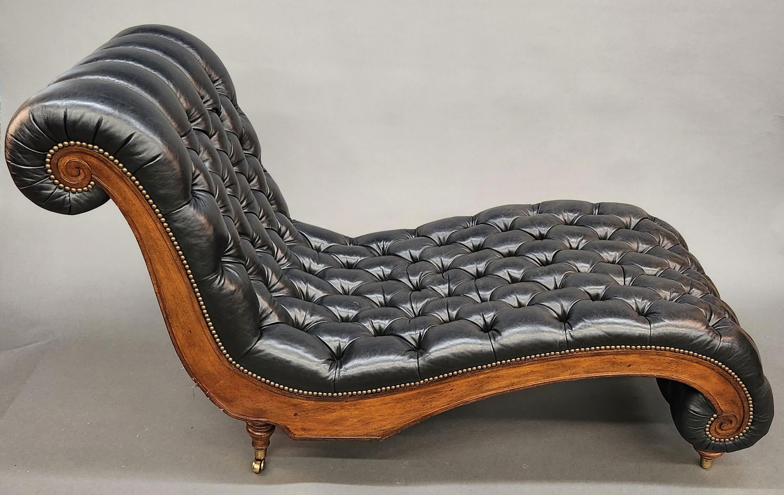 Henredon Chesterfield chaise lounge: A Henredon Chesterfield mahogany and button tufted black leather chaise lounge, Circa 1980s. Two side drawers. 39" x 65" x 27". Provenance: From the estate of U.S.M.C. Four Star General Alfred M. Gray