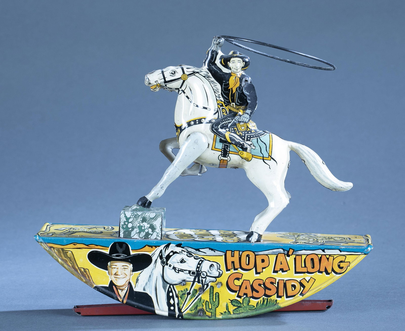 Marx Hop A'long Cassidy tin litho windup rocker: A Marx Hop A'long Cassidy tin lithograph windup rocker. 9 1/2" x 11 1/4" x 2 1/4" Condition: Working condition. Discoloration, fading and wear.