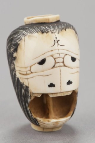 An ivory netsuke of a lantern.: Osaka, , Mid 19th century. In the form of the Ghost of Oiwa. The back is engraved with the Buddhist prayer, Namu Amida Butsu (Save us, merciful Buddhain) and Zokumyo Iwa Jo (in the woman, (O)iwain). S