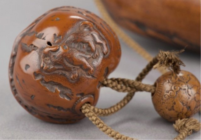 A kumari netsuke of three puppies.: By Hidari Issan, Iwashiro, Mid 19th century. Two seated in close proximity to each other, one facing away and the other forward, the third one on the opposite side and standing with the signature just