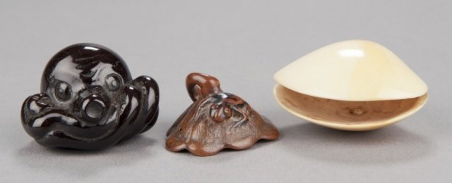 A group of three netsuke.: The first, mid 19th century, horn octopus with tentacles curled under the body in a compact form, the pupils of the octopus are carved in relief. 1 1/8in (3cm). The second, late 18th century, wood tre