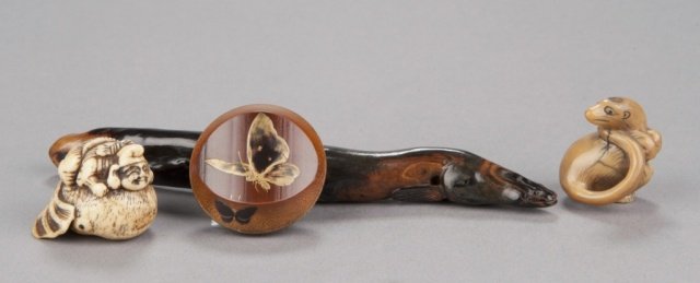 A group of four netsuke, various materials.: Mid 19th century. The first, in bone, Ebisu riding a giant fish, There are traces of an old signature that has been eradicated by wear. The bone is possibly the jaw-bone of a sperm whale (see Penniman