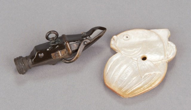 A group of two netsuke, various materials.: The first, early 19th century, a model of a Portuguese matchlock firearm fashioned in iron with details in brass, the stock and sides are lacquered. 2 3/4in (7cm). The second, an mid 19th century, a m