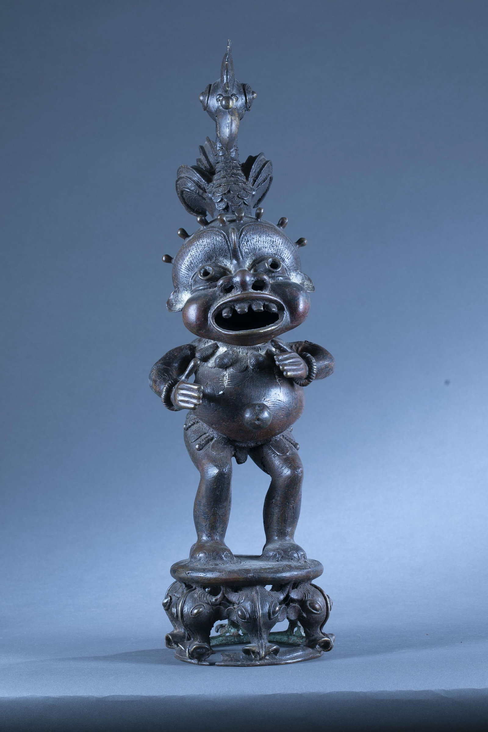 Bronze figure, Cameroon.: A bronze figure of a standing male form on a stool. Cameroon. 25 1/4" x 9". Condition: Residue.