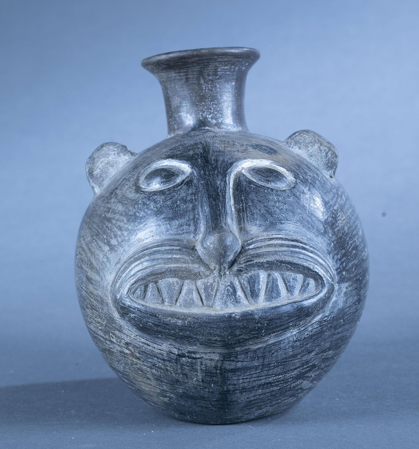 Chimu jaguar vessel, Peru.: A Chimu blackware vessel of a jaguar head. Peru. 7 1/2" x 6 1/2". Condition: Chipped rim, abrasions. Provenance: From the collection of Dale Spoor.