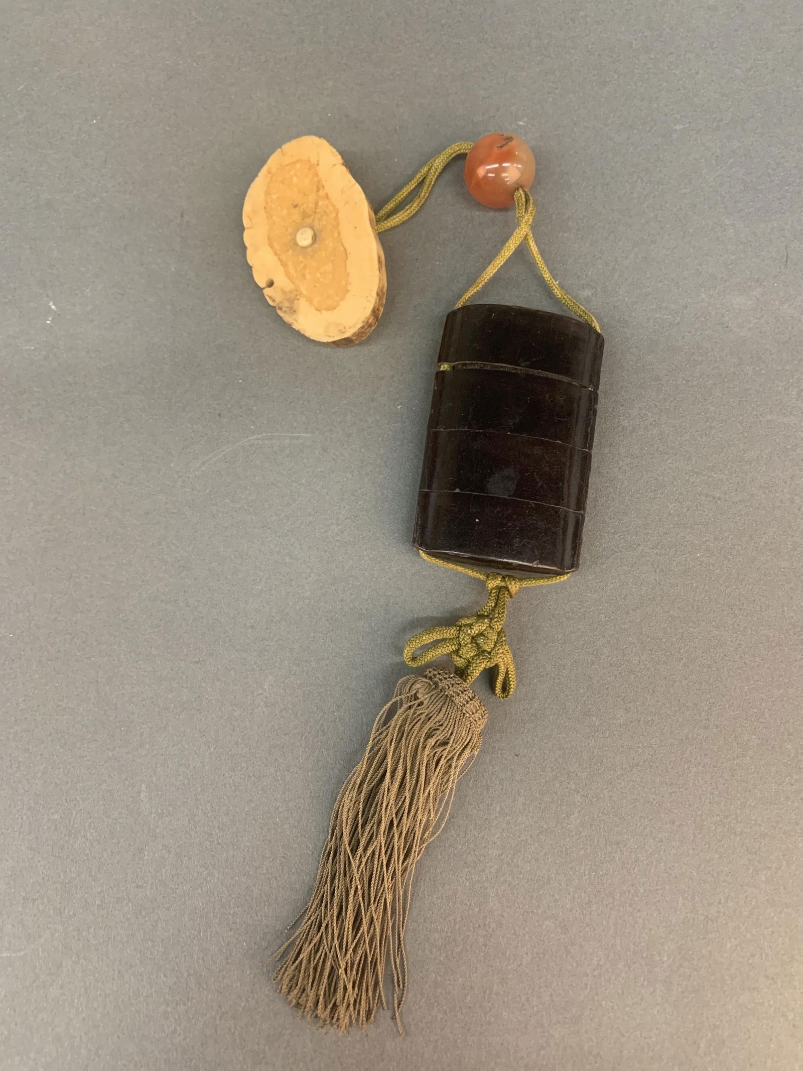 Japanese inro, ojime, and netsuke.: A Japanese lacquer wood inro, agate ojime, and fossilized bone cross section netsuke. 8 1/4" overall. 3" x 2" x 1/2".