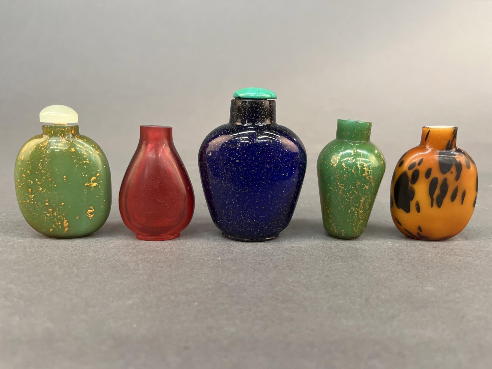 5 Glass snuff bottles.: A group of five glass snuff bottles. Largest: 3 1/4".