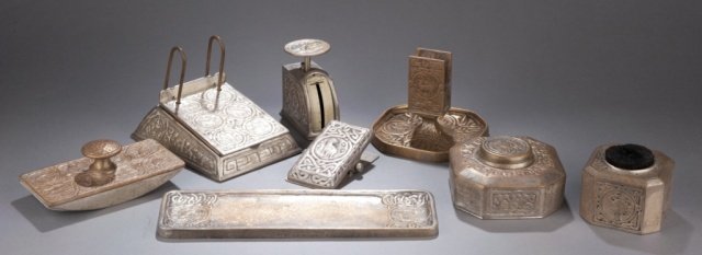 7 pc. Tiffany and Co. gilt bronze desk set 1930s: Group of seven Tiffany and Company zodiac pattern gilt bronze desk items. c. 1930s. Comprised of: small scale, pen wipe, letter holder, inkwell, rocker blotter, pen rest, desk calendar, and paper clip