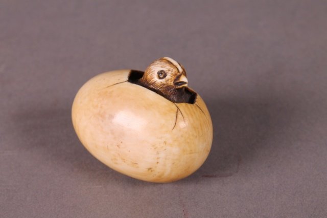 Chicken in an egg ivory netsuke.: An ivory netsuke of a hatchling in an egg. Early to mid 20th century. 1 1/2"h x 2 3/4".