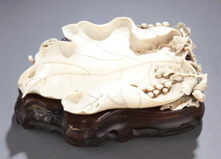 Chinese carved ivory leaf dish, 19th century.: A Chinese carved ivory leaf dish with branch and berries. 19th/early 20th century. With carved squirrel on edge. Wood base. Without base: 1/2"h x 7"l x 4 1/2"w.