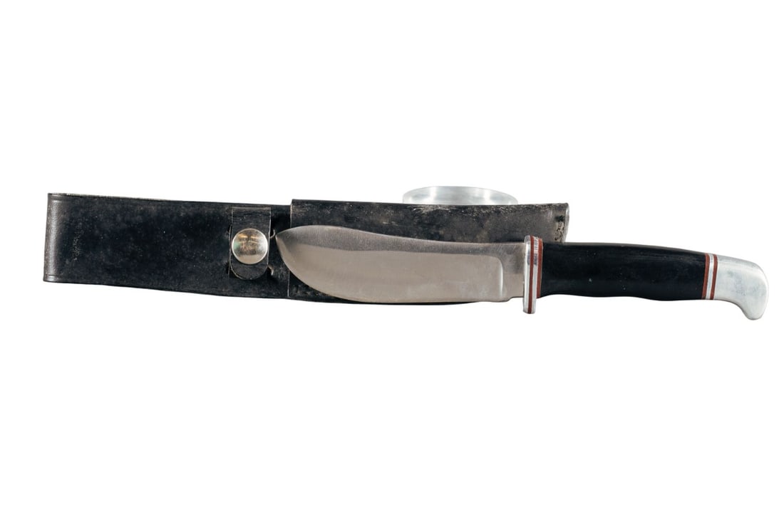 1960s Buck Model 103 skinner knife: A Buck Model 103 skinner knife with unmarked leatherscabbard. Circa 1961-1967. 4 1/8" blade. Marked "BUCK." 8 1/4" overall.