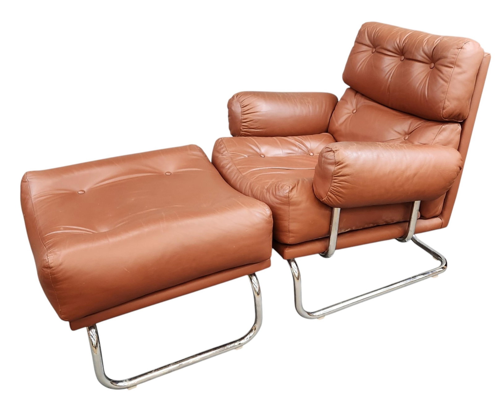 Modern tufted leather tubular chair with ottoman.: A modern tufted leather tubular chair with ottoman. 32" 31" x 34" and 18" x 25" x 24".