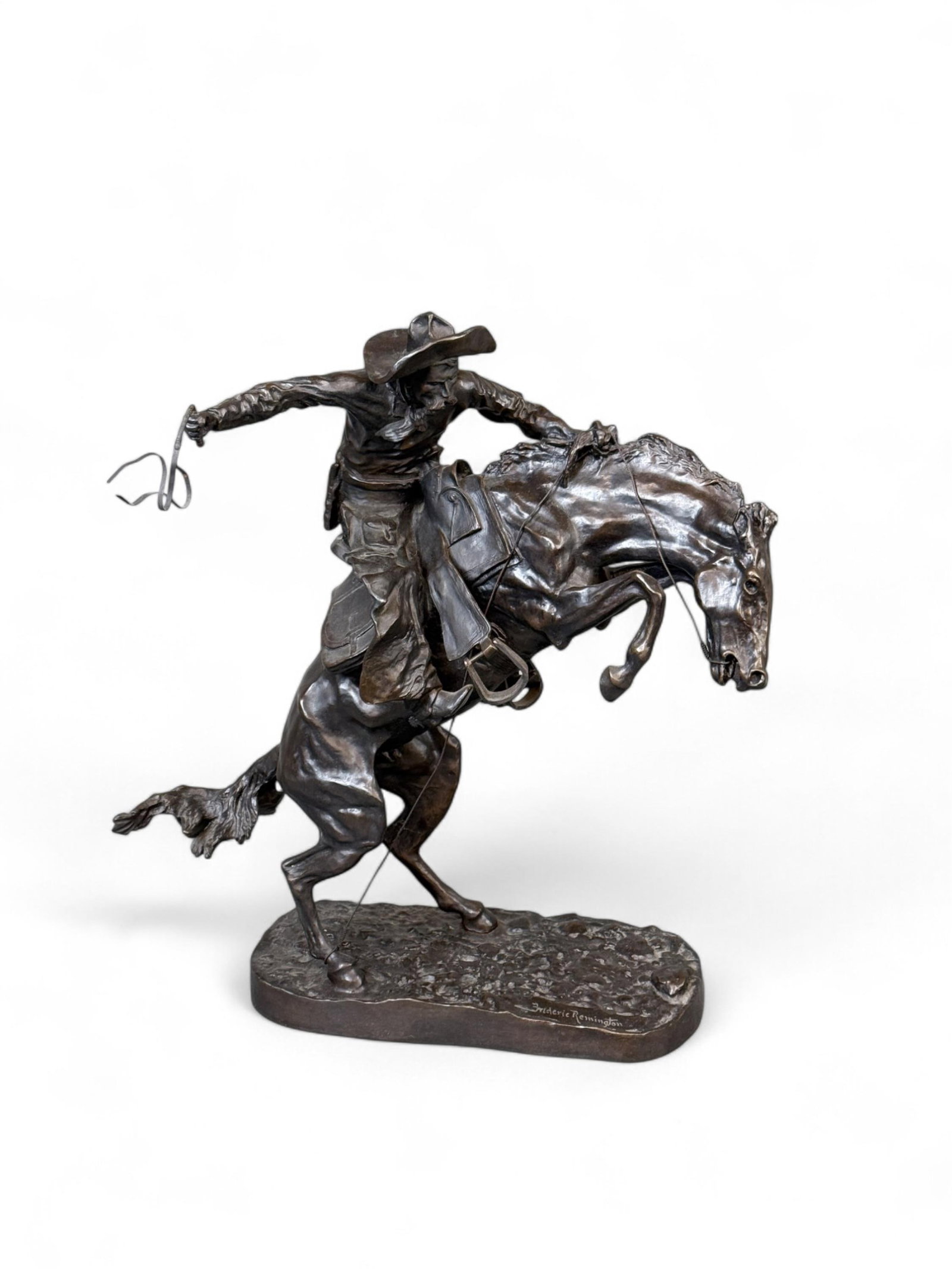 After Remington, "Bronco Buster," Bronze.: After Frederic Remington (New York, 1861-1909). "Bronco Buster" bronze sculpture. Marked on base. 22 1/4" x 21". Condition: Riding whip is not attached and has damage. Provenance: From the collection 