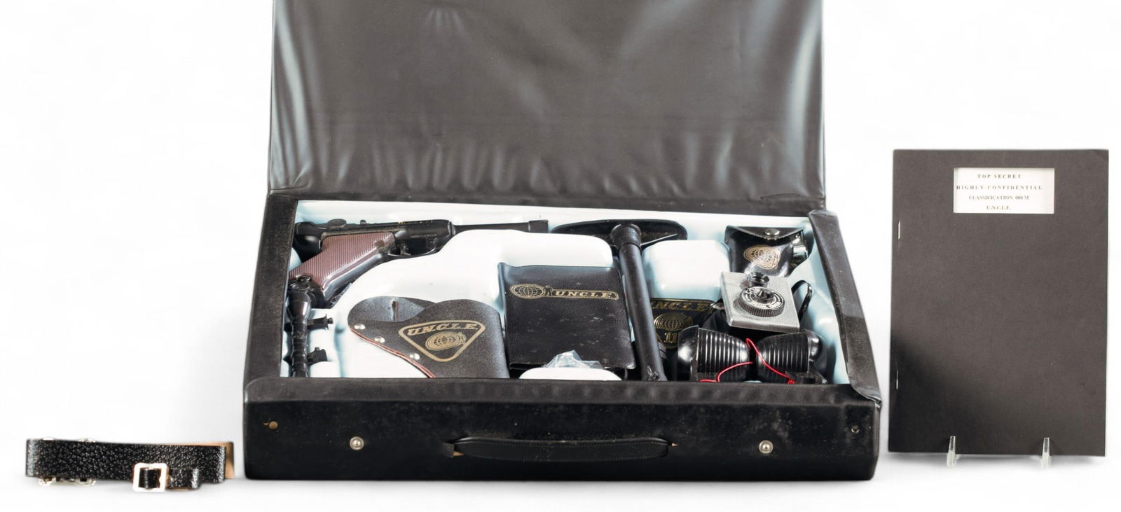 Lone Star The Man from U.N.C.L.E. Spy Attache Case: A 1966 Lone Star The Man from U.N.C.L.E. Spy Attache Case. Black vinyl suitcase with plastic insert. Missing pen. Includes Luger cap gun with stock, scope, silencer, and holster. Gang Buster! cap side