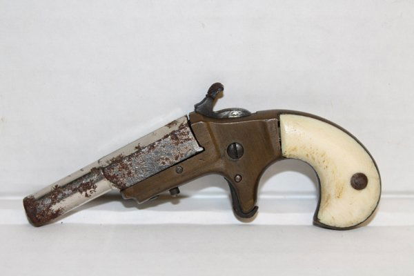 Single shot pocket derringer pistol.: Brass frame. Ivory or faux ivory grips. Possibly .22 caliber. 2" barrel. 4" overall. Condition: Surface rust to barrel. Mechanically functional. This firearm is defined as "Antique" by the BATF.