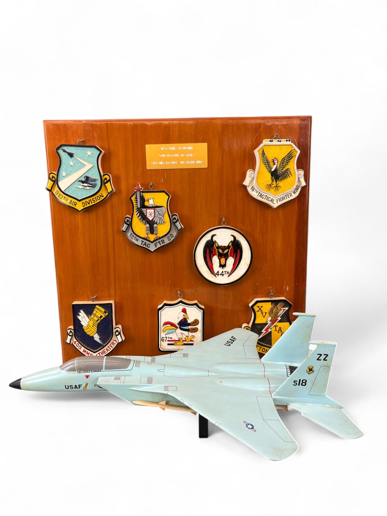 Gen. Brown F-15 Eagle model and emblems.: Lt. Gen. James R. Brown, USAF F-15 Eagle model and emblems on wood. 18 1/2" x 14 1/2" x 18 1/2". Provenance: From the Estate of U.S.A.F. Lt. General James R. Brown (1930-2015).