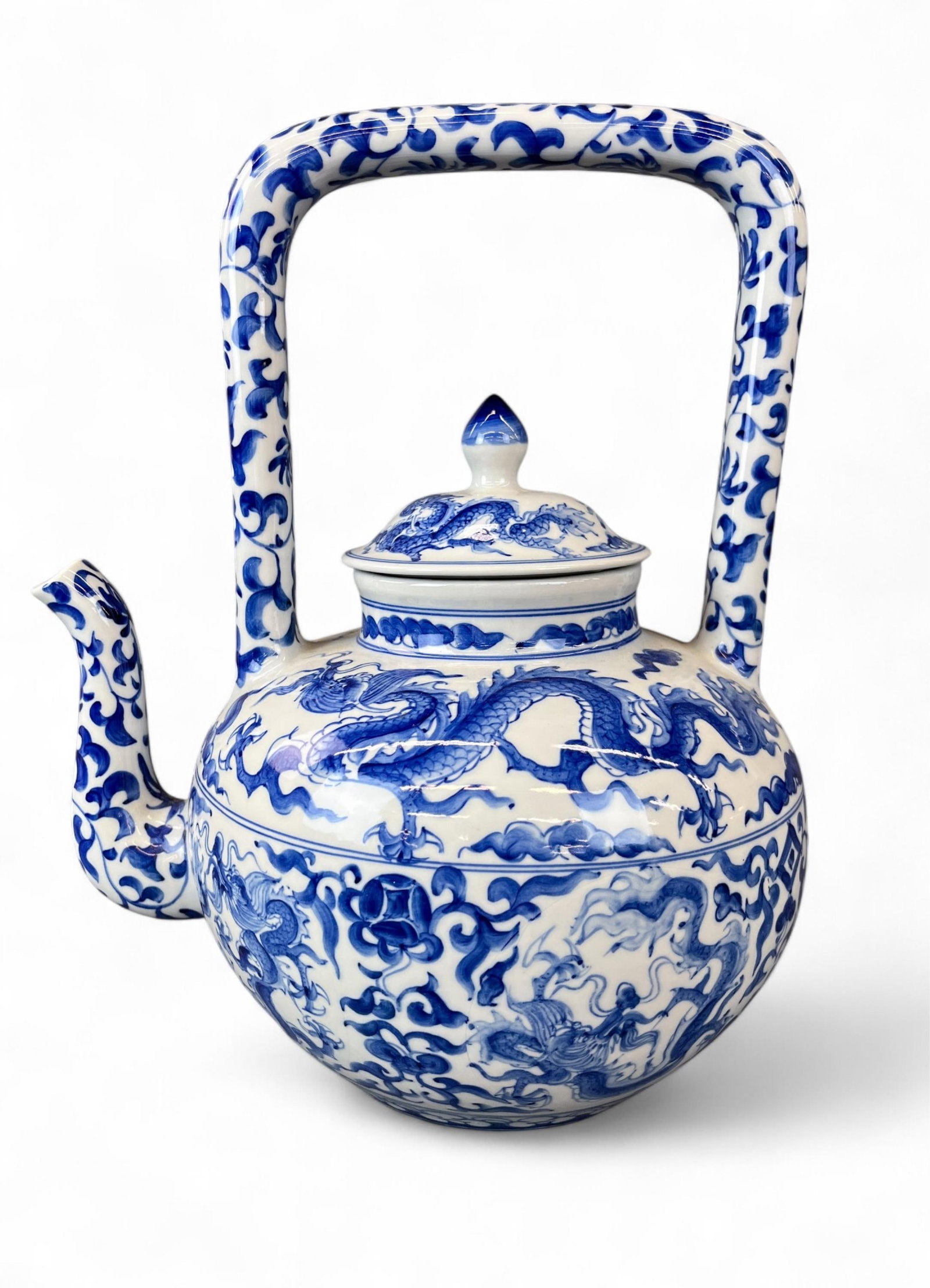 Chinese blue and white porcelain teapot.: A Chinese blue and white porcelain teapot with cover, decorated with dragons among clouds and scrolling lotus. Late 20th century. Marked on base. 12 3/4" x 11". Condition: Abrasions, light surface dir