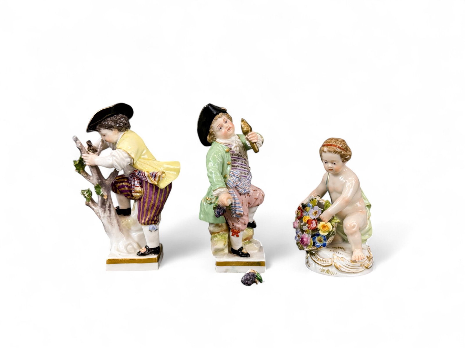 3 Meissen figures.: A group of three Meissen figures. Marked on bottom. Smallest: 3 1/4" x 2". Largest: 4" x 2". Condition: Broken flowers, leaves, and grape bundle, areas of repaint and previous repairs. Provenance: Fro