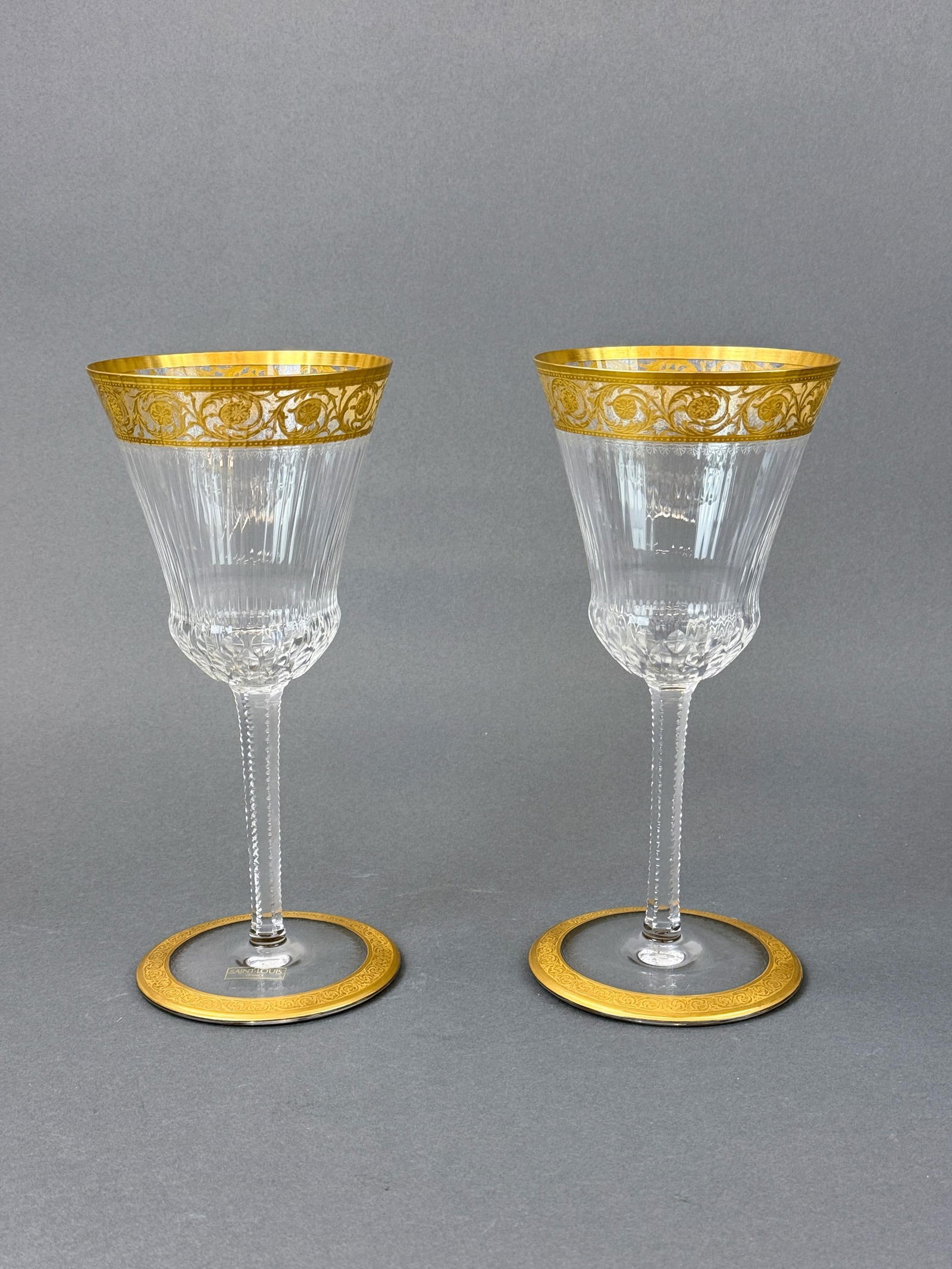2 St. Louis "Thistle" commemoration glasses.: A pair of St. Louis "Thistle" gilt crystal commemoration glasses. Acid marked on base. One has sticker. 10 3/8" x 4 6/8".