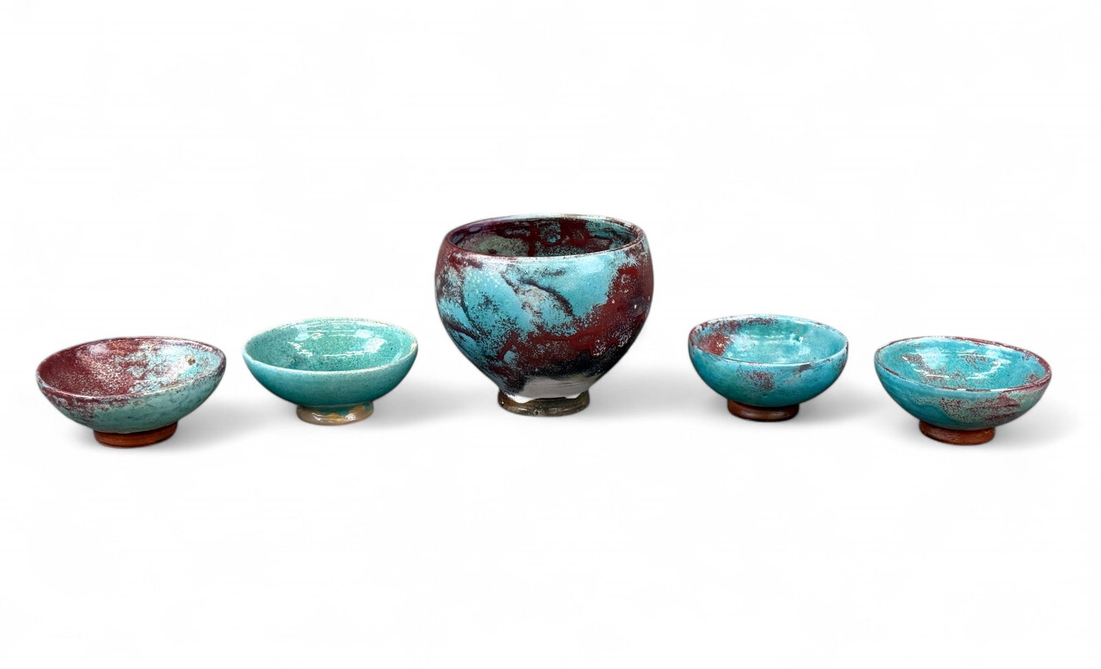 5 Jugtown ware bowls.: A group of five Jugtown ware bowls. Seagrove, NC. 20th century. Four small and one large bowl in light blue and deep purple glaze. Stamped on base. Smallest: 2" x 4 1/4". Largest: 4 3/4" x 5 3/4". Con
