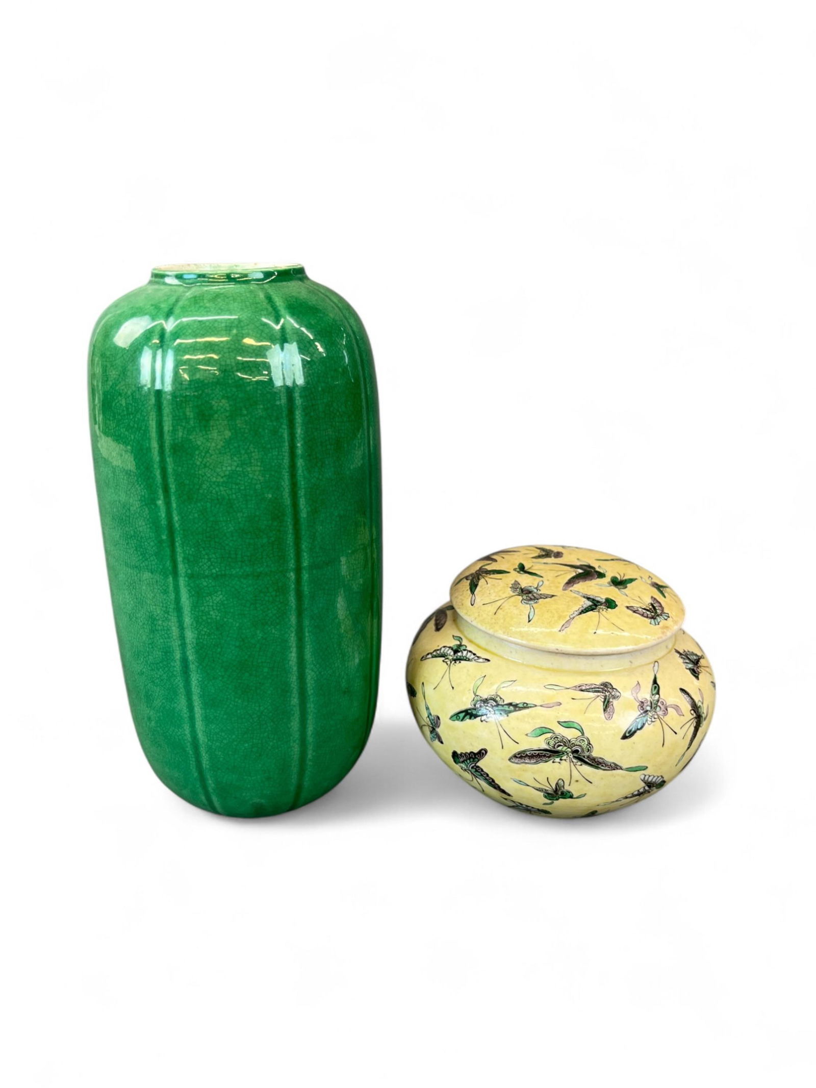 2 Chinese porcelain vessels, 20th century.: A group of two Asian porcelain vessels. ++ Green vase. 8 1/2" x 4" x 4". ++ Famille jaune covered jar decorated with moths and butterflies. Michael B. Weisbrod label on bottom. 3 7/8" x 5 1/2" x 5 1/2