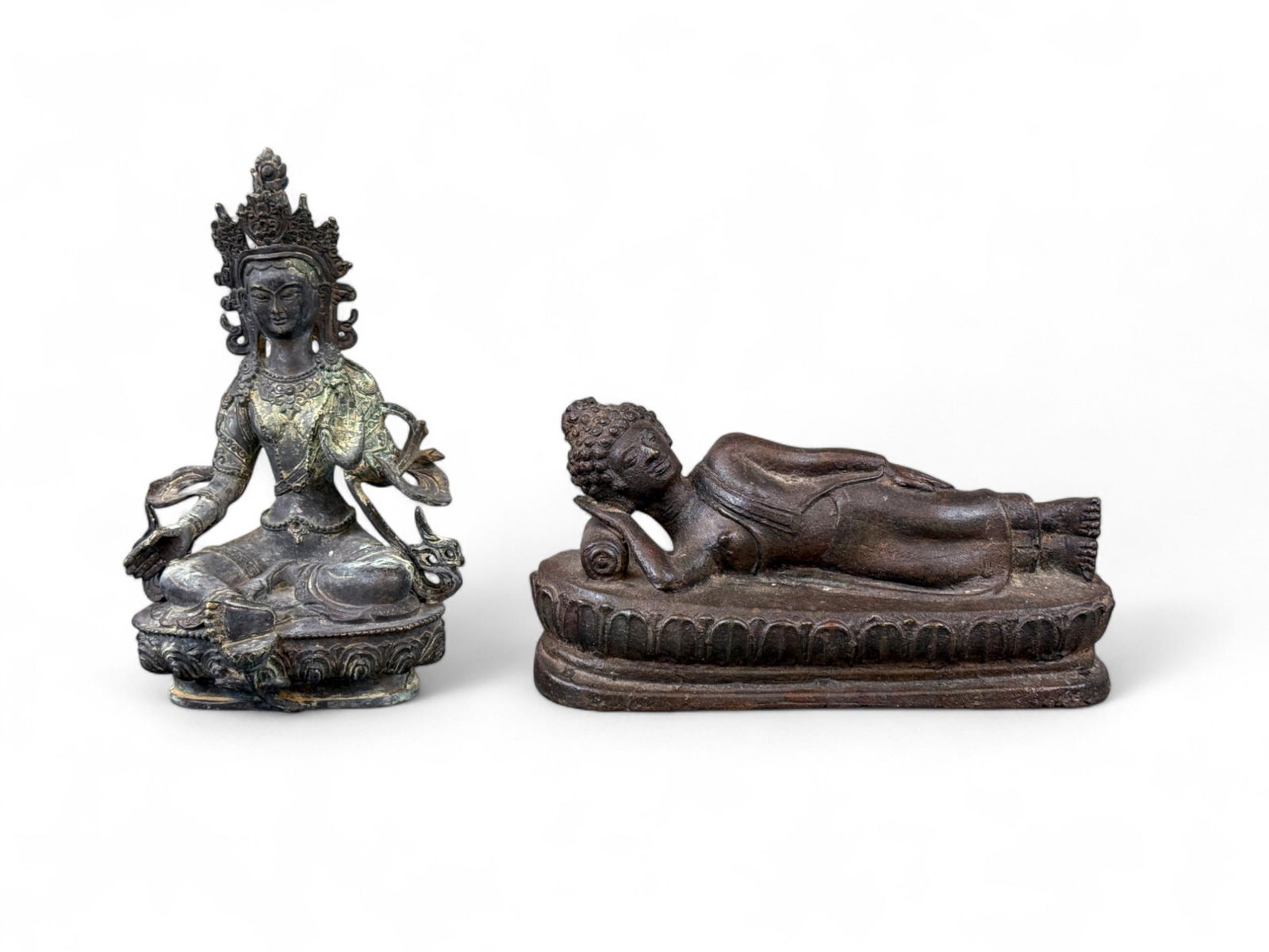 2 South Asian bronze deities.: A group of two South Asian bronze deities. ++ Tibetan bronze figure of a seated Tara. 8 1/2" x 5 1/2". ++ Thai bronze figure of the Buddha sleeping. 4 1/2" x 9".