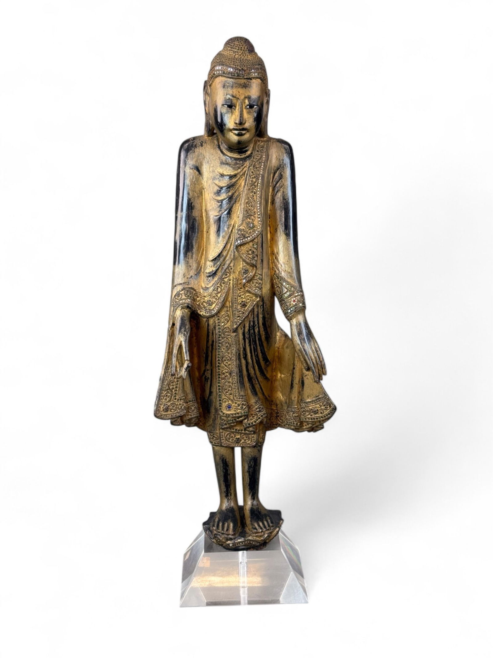 SE Asian gilt and lacquer wood standing Buddha.: A carved gilt and lacquered wood standing Buddha figure. Late 19th to early 20th century.