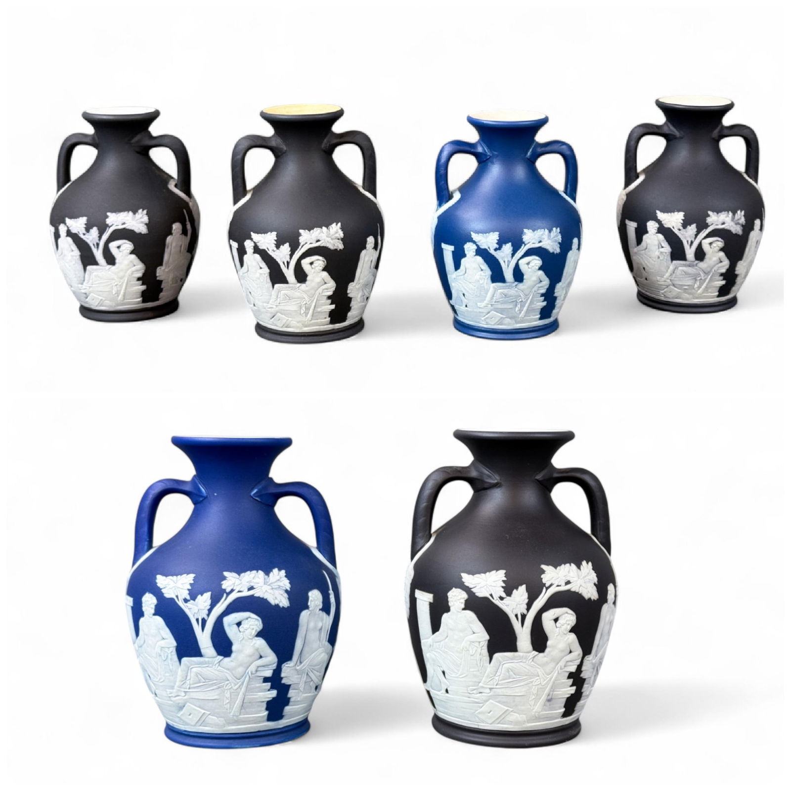6 Wedgwood Portland vases, 1892-1908.: A group of six blue and black Wedgwood Jasperware Portland vases. Circa 1892 to 1908. Marked "WEDGWOOD" and "England" on bottom. Smallest: 4" x 2 7/8". Largest: 5 1/4" x 3 1/4". Condition: Surface dir