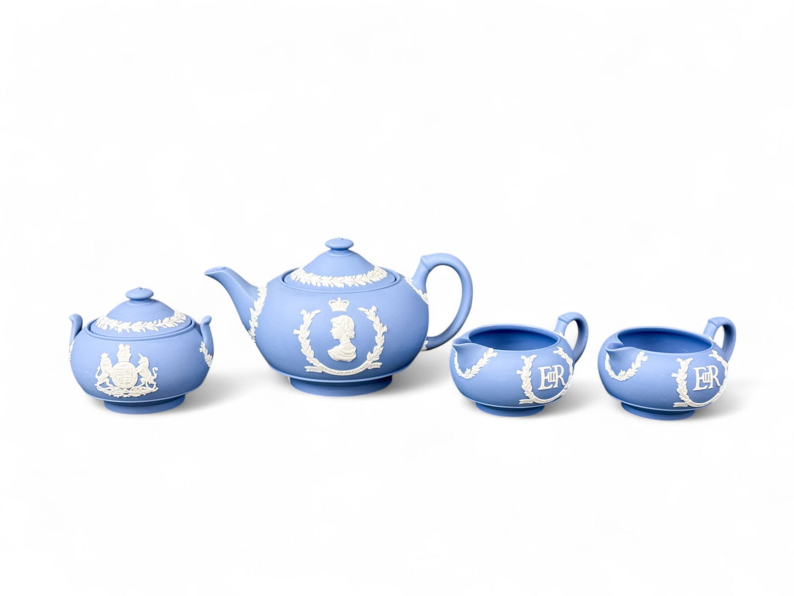 Wedgwood Queen Elizabeth II Coronation tea set.: A 1953 Wedgwood Jasperware Pale Blue Queen Elizabeth II Coronation tea set. Including teapot, two creamers, and sugar. Smallest: 2 3/4" x 5 1/2" x 4". Largest: 5" x 9" x 6".