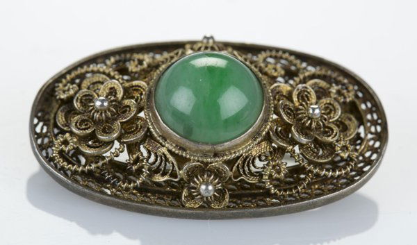 Silver Chinese made oval brooch/pendant w/ jade: A silver Chinese made oval brooch/pendant with central circular jade stone. 7/8"l x 1 1/2"w