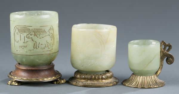 Group of three small jade Chinese cups: A group of three small jade Chinese cups on brass mounts. 20th century. Two marked, "Nicholas Haydon New York City" on bottom. Largest: 3 1/2"h x 2 1/4"diam.