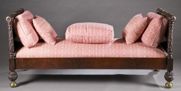 Carved mahogany daybed, 19th c.: An American Classical mahogany day bed. 2nd quarter 19th century. Each end with acanthus carved blanket roll mounted to the paneled side, supported by carved ball legs terminating in brass ball feet.