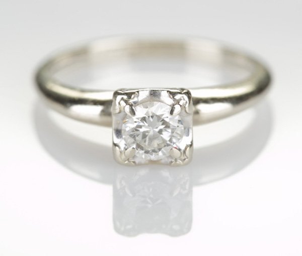 Solitaire diamond ring: A Round 0.5 CT diamond set in square setting, 14KT white gold with oval box. Tw. 0.095 ozt.