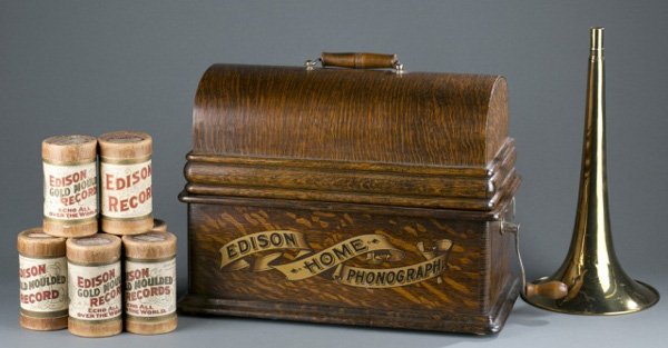 Edison home phonograph, horn, cylinders.: An Edison standard cylinder phonograph with horn and 7 records. Early 20th century. 12"h x 16"w x 8 1/2"d.