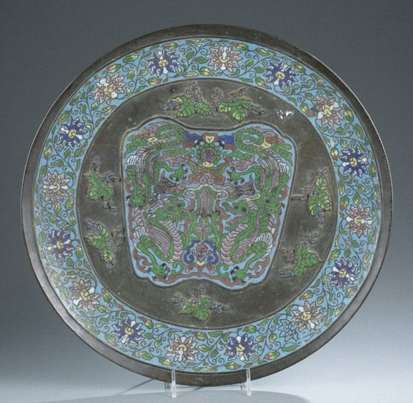 Japanese bronze polychrome charger.: A Japanese bronze polychrome charger with central medallion of dragons among clouds flanked by floral motifs. Late 19th/20th century. 2"h x 18"diam.