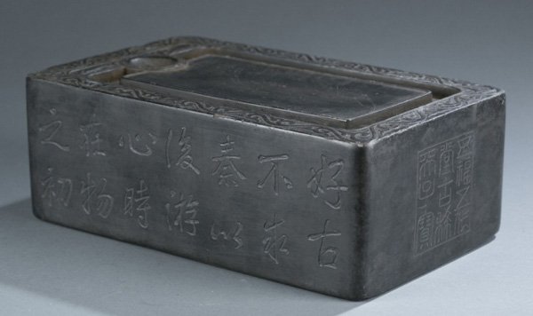 Chinese carved and inscribed inkstone.: A Chinese carved and inscribed inkstone. Etched characters on sides and interior. 9 1/2"h x 6"w x 3 1/2"d. Condition: Chips around lip.